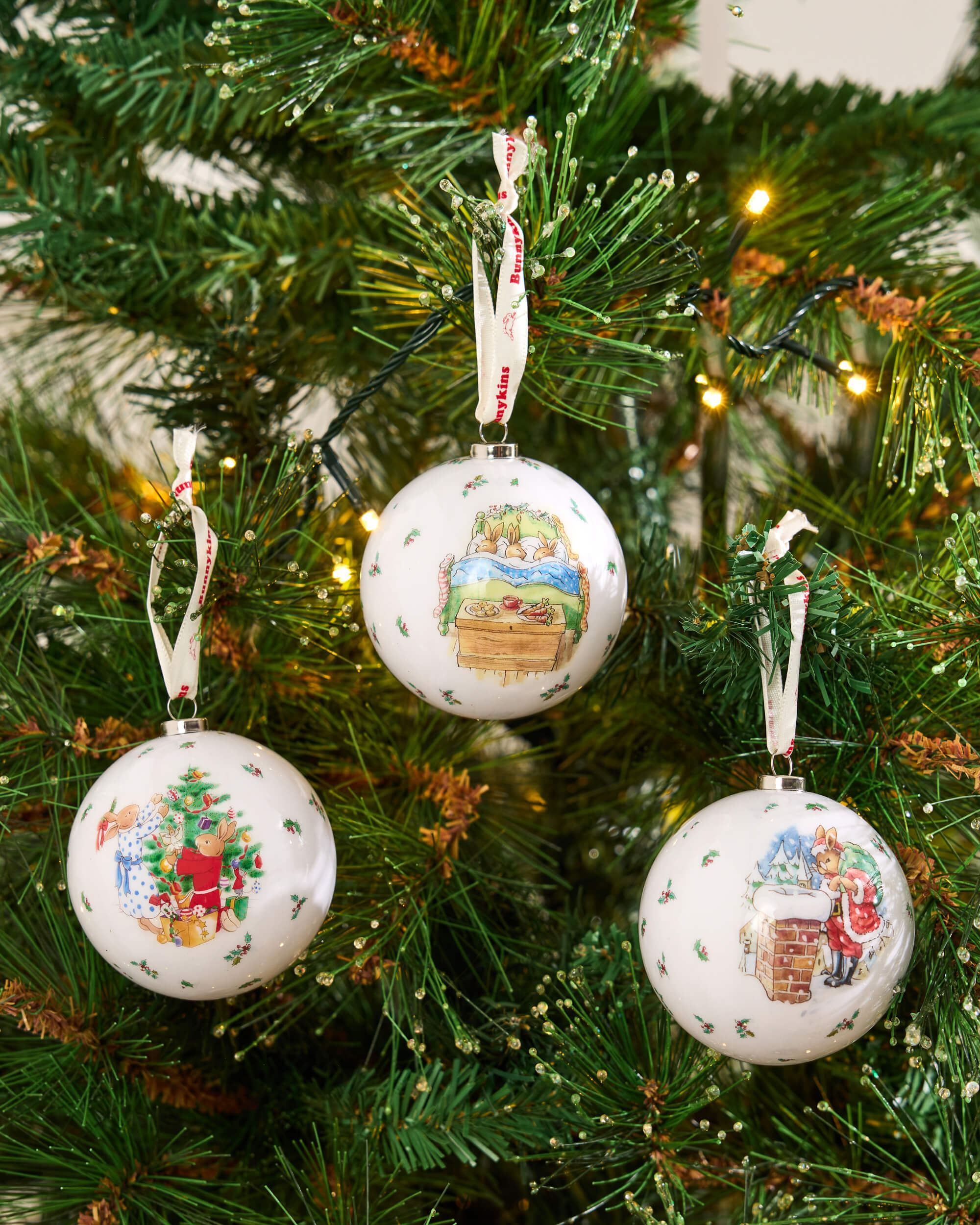 Bunnykins Christmas baubles hanging among festive tree branches