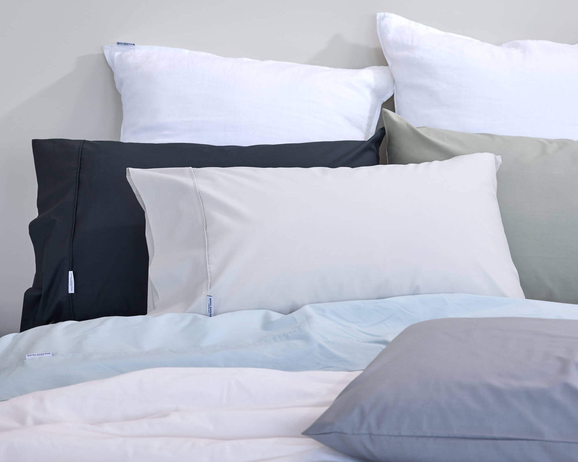 Royal Doulton Stirling sheet set in white, charcoal, sage and pale blue on a bed