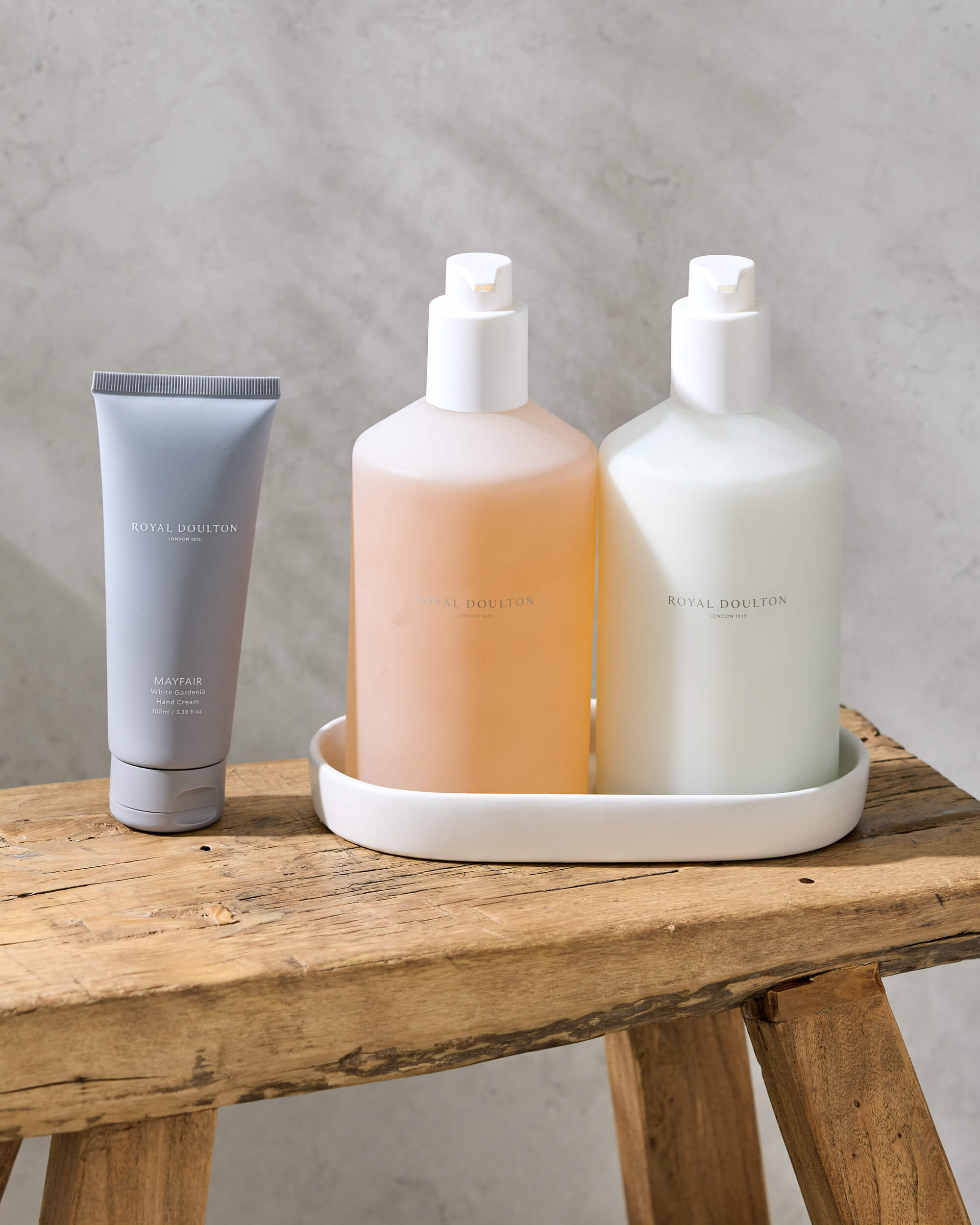 Royal Doulton Mayfair body care bottles in a tray on a wooden stool