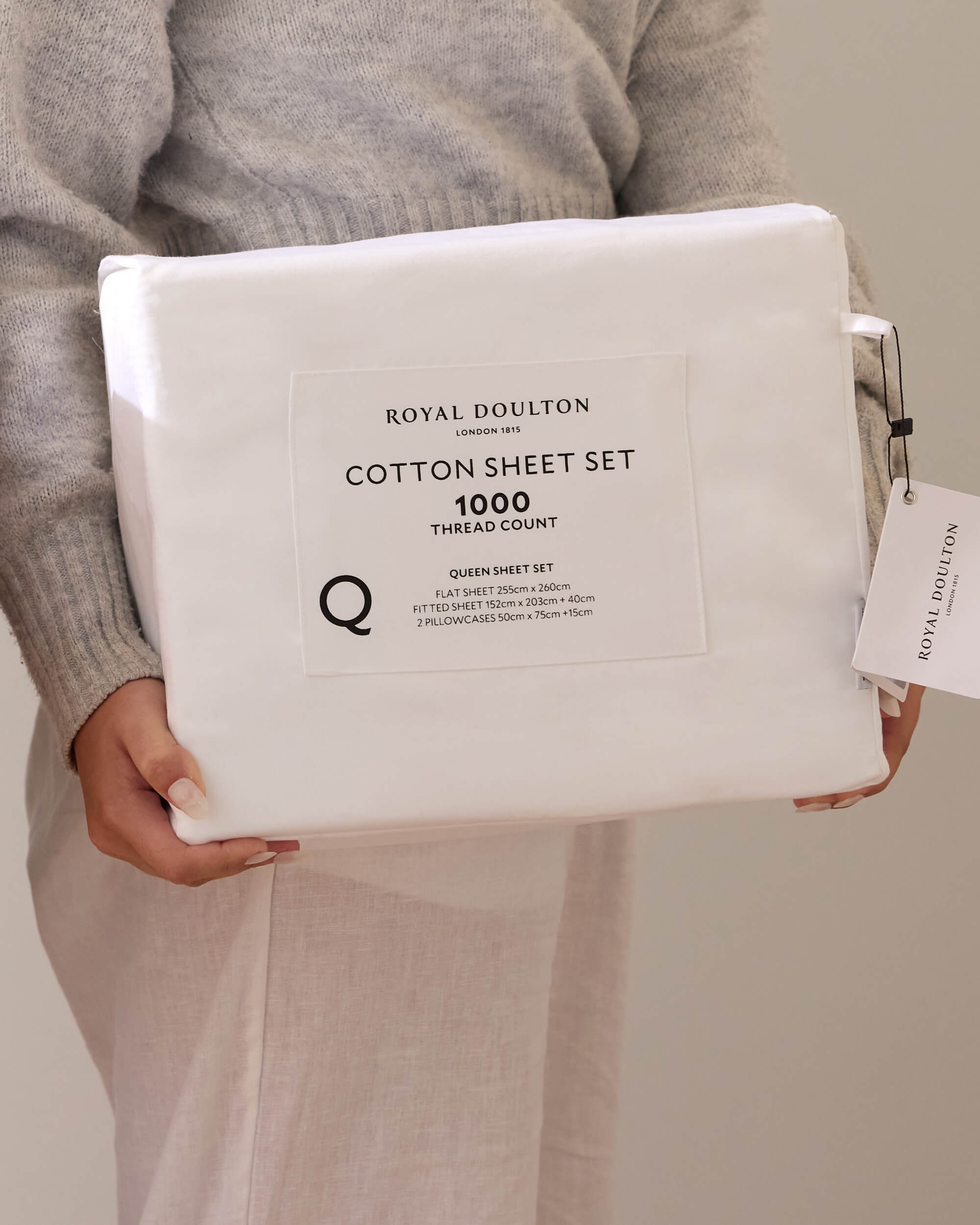 Person holding a packaged white Royal Doulton Aria sheet set
