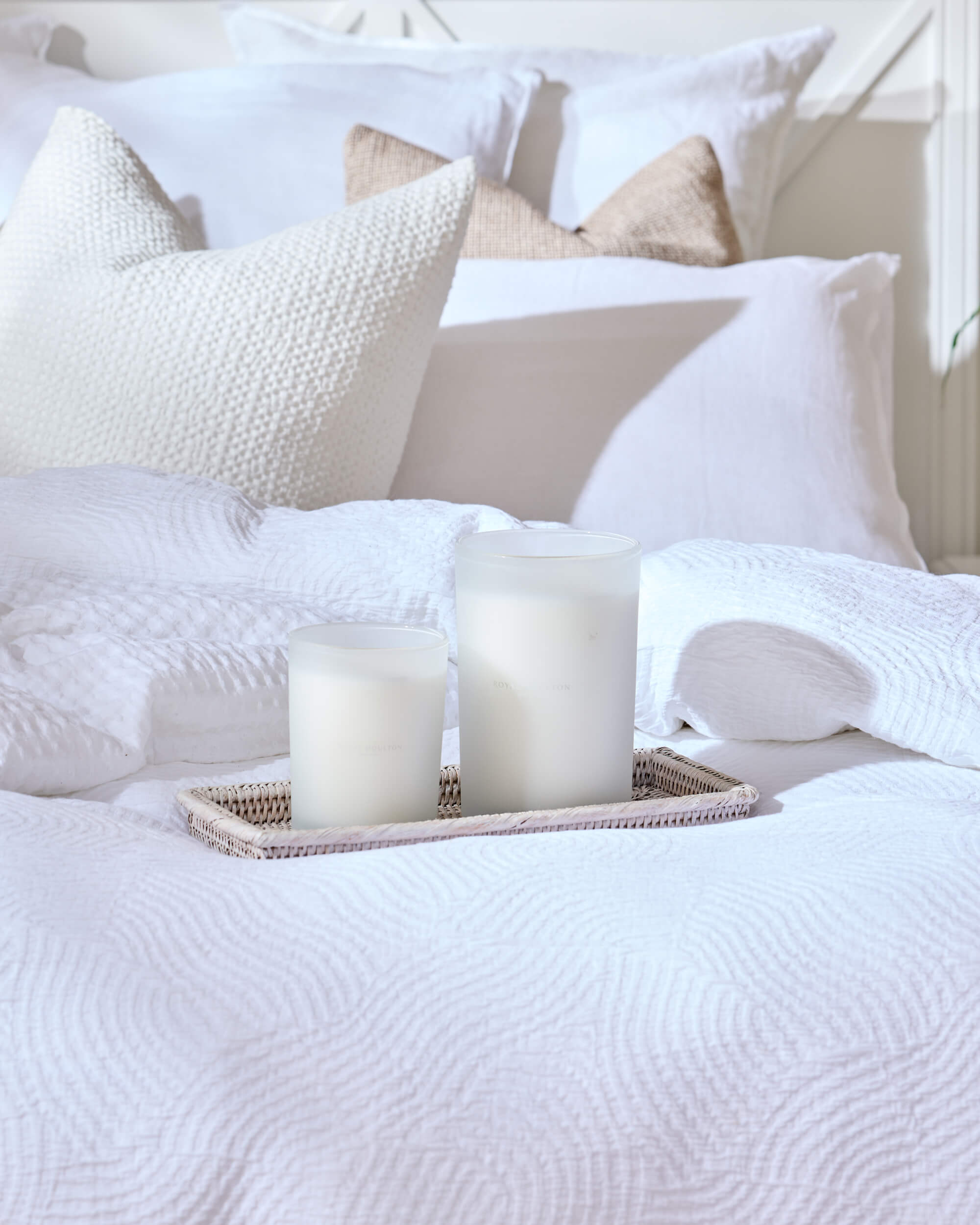 Royal Doulton white bedding with textured pillows and a tray of candles