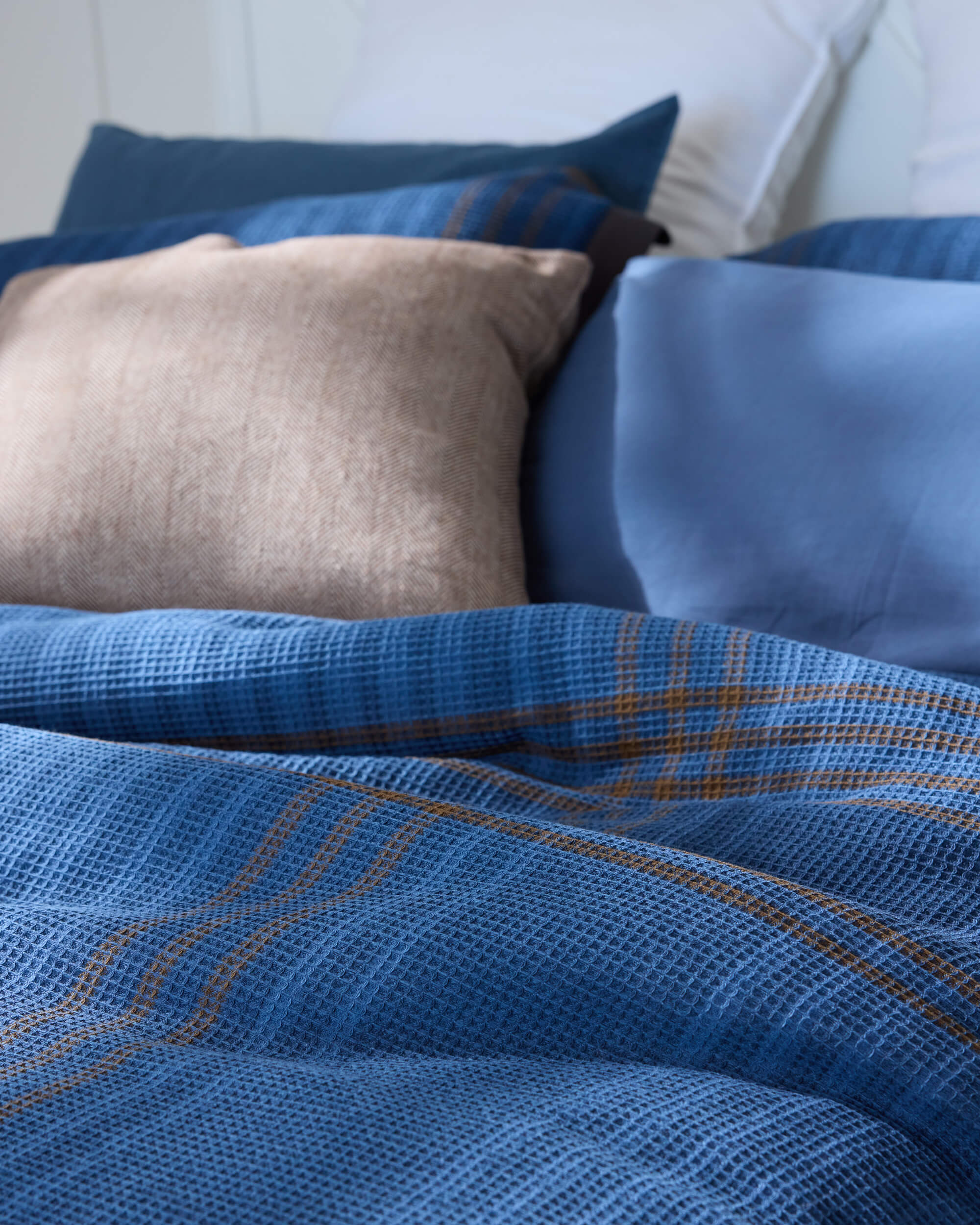 Royal Doulton Hampshire blue textured check bedding styled with white and taupe pillows